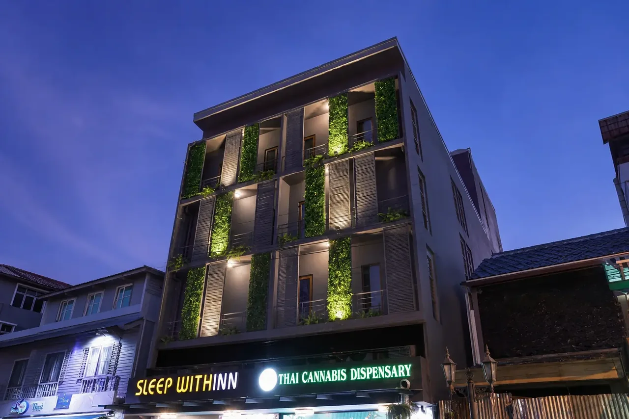 Sleep Withinn hotel exterior at night with illuminated greenery and signage