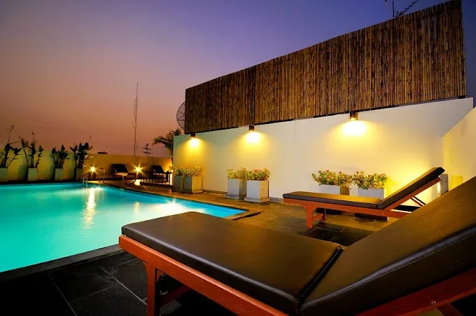Original Sleep Withinn rooftop pool at twilight with sunbeds and wall lighting